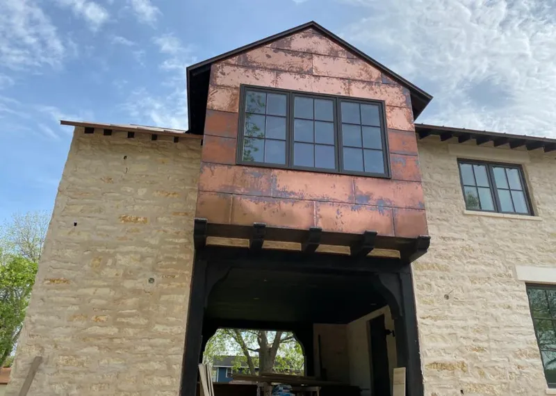 Copper metal panel facade on a stone building for Skylight Installation in Irondale