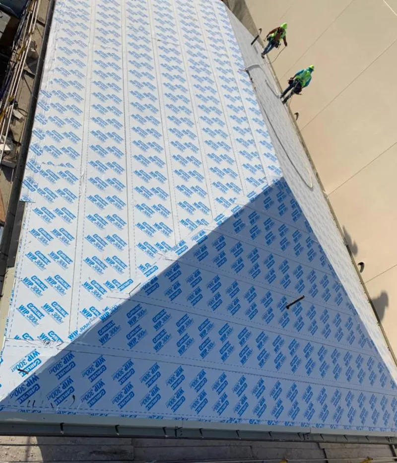 Professional roofers installing underlayment on a metal roof in Irondale